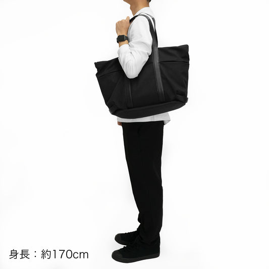 北海道産の牛革をふんだんに使用し高級感がありながら、高い機能性を併せ持つ「Lake ユーティリティトートバッグ」を身長約170cmの方が肩掛けしたイメージ