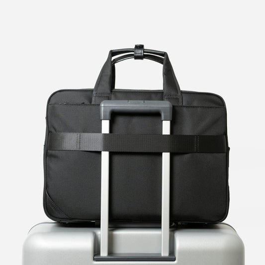 Floe ワーク&デイリーブリーフケースはスーツケースのハンドル部分に差し込んで固定するためのセットアップベルト付き。