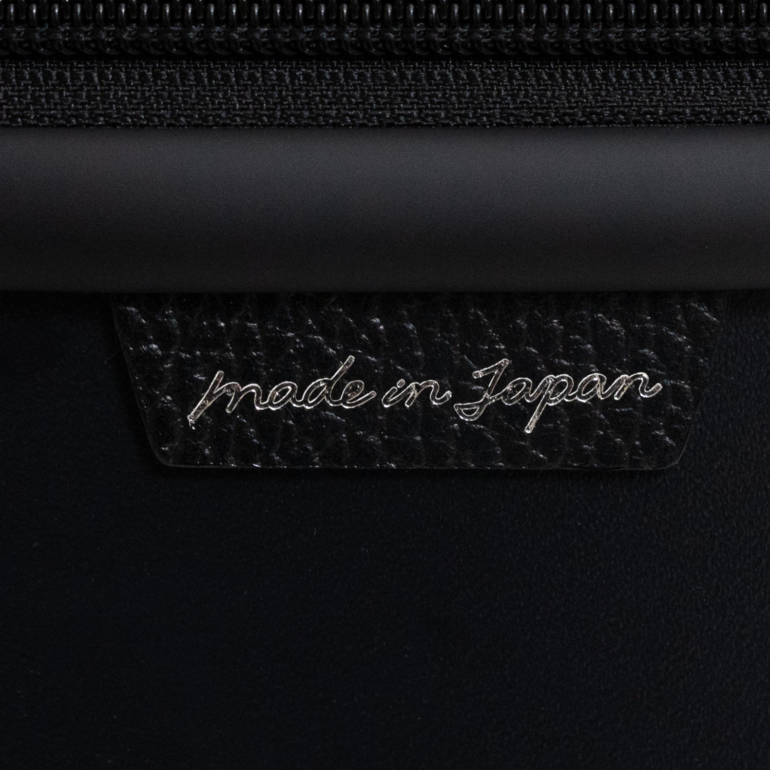 「N700系typeA東海道新幹線モケットハードスーツケース」の側面には、北海道産の牛革シュリンクレザーにメイドインジャパンの刻印が入った日本製の証がついています。