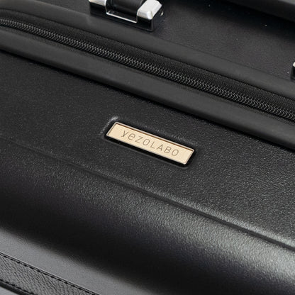 Trunkレザーバンドハードスーツケースには北海道産シラカンバ材を使用した「yezoLABO（エゾラボ）」ブランドロゴマークを配置しています。