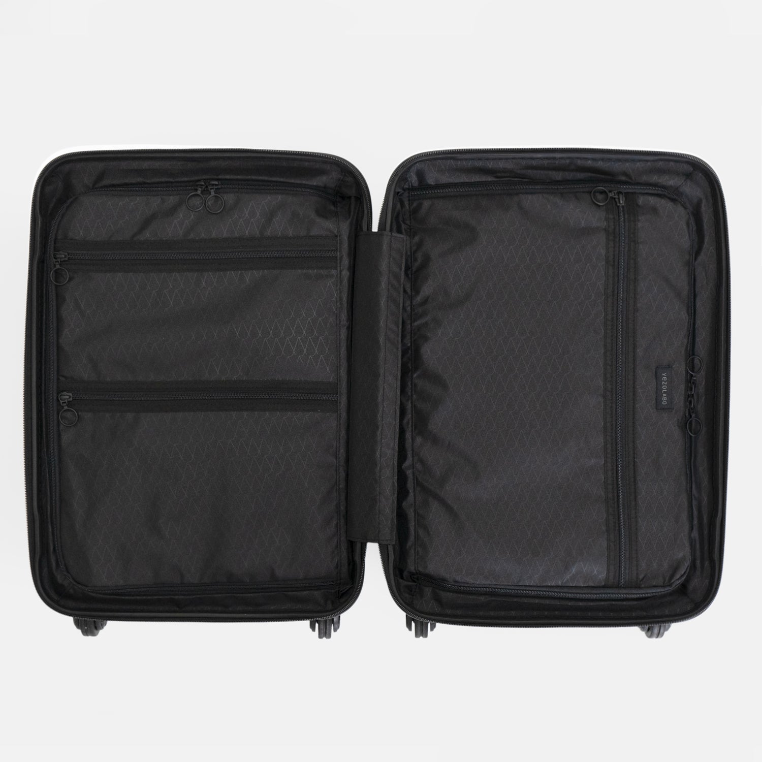 Trunkレザーバンドハードスーツケースの内装には両側に荷物を収納するファスナー仕切りとファスナーポケットを配置しています。本体ボトム側には、縦に渡る広いファスナーポケットを、トップ側には横に渡るファスナーポケットを2つ配置。細かい荷物の収納に最適です。