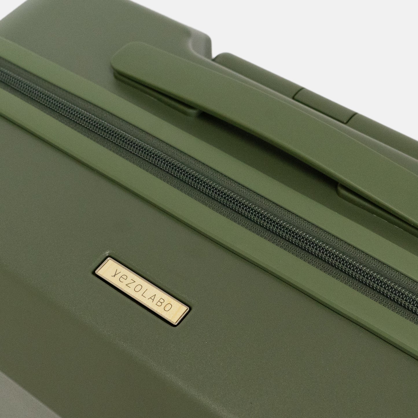Brush北海道カラーパレットスーツケース（キャリーケース）には北海道産シラカンバ材を使用した「yezoLABO（エゾラボ）」ブランドロゴマークを配置しています。