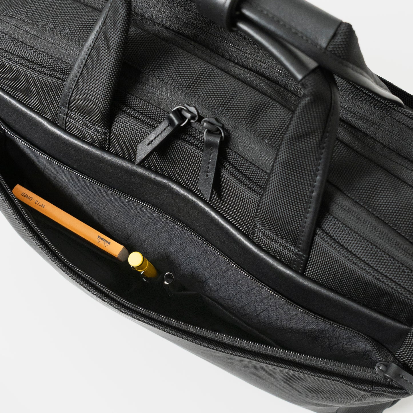 Floe ワーク＆デイリーブリーフケースの前ポケットには、ペンが1本ずつ収納できるペン差し仕切りポケットが2つ、メモ帳や名刺入れなどが入るサイズの仕切りポケットが2つついています。