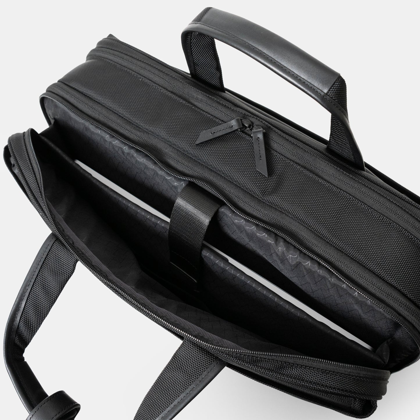 Floe ワーク＆デイリーブリーフケースのクッション入り仕切り部分には、15.6インチノートPCが収納可能です。反対側には3つの仕切りポケットがついており、メモ帳や名刺入れ、ケーブル等の小物を収納いただけます。