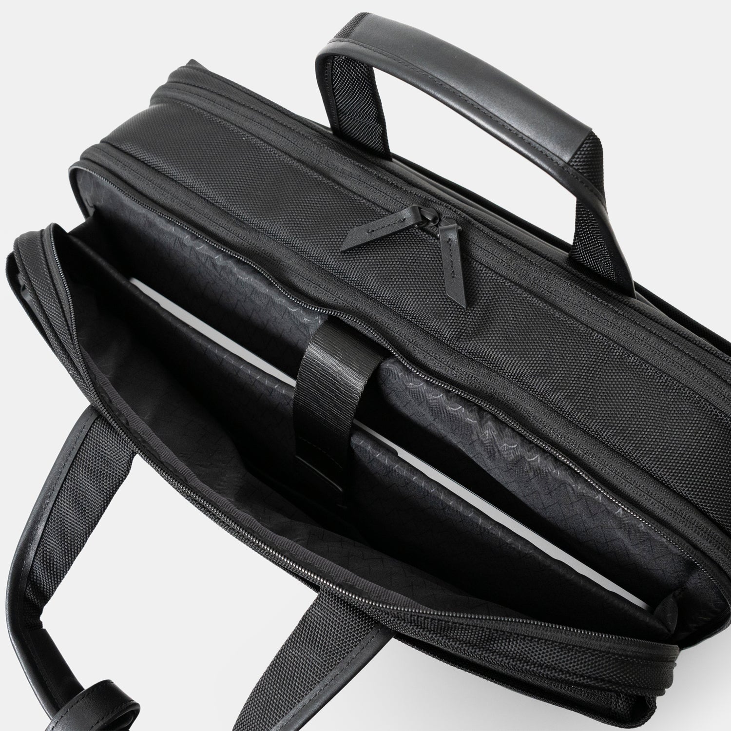 Floe ワーク＆デイリーブリーフケースのクッション入り仕切り部分には、15.6インチノートPCが収納可能です。反対側には3つの仕切りポケットがついており、メモ帳や名刺入れ、ケーブル等の小物を収納いただけます。