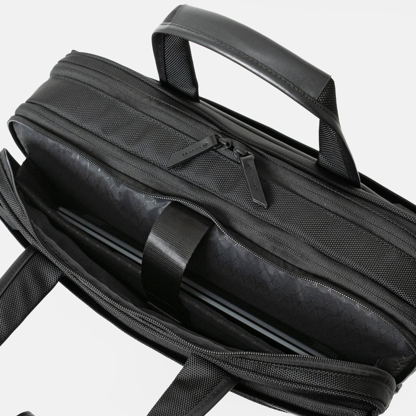 Floe ワーク＆デイリーブリーフケースのクッション入り仕切り部分には、14インチノートPCが収納可能です。反対側には3つの仕切りポケットがついており、メモ帳や名刺入れ、ケーブル等の小物を収納いただけます。