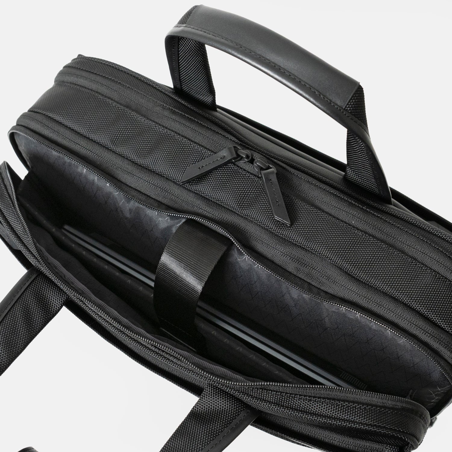 Floe ワーク＆デイリーブリーフケースのクッション入り仕切り部分には、14インチノートPCが収納可能です。反対側には3つの仕切りポケットがついており、メモ帳や名刺入れ、ケーブル等の小物を収納いただけます。