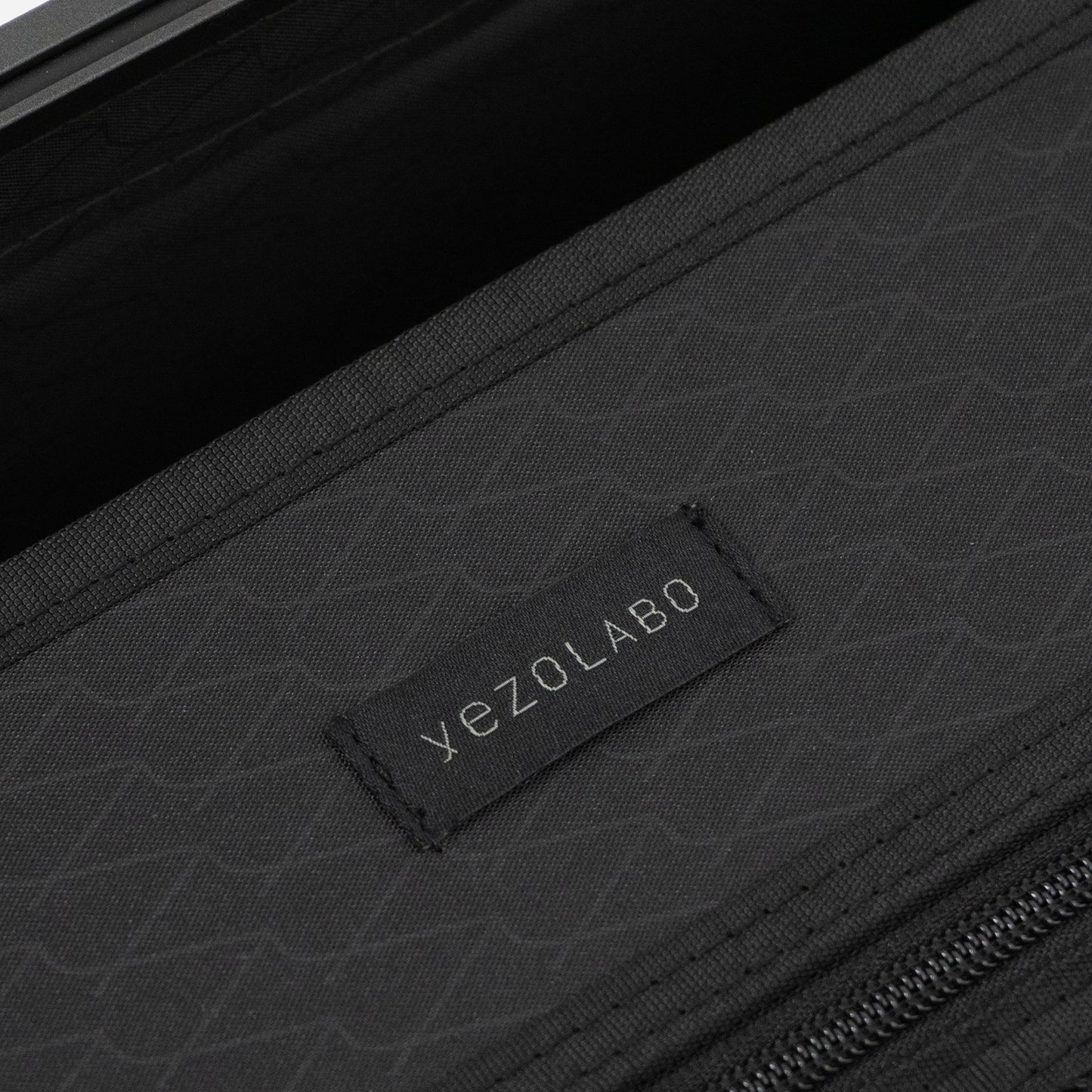 アイシクル フレームスーツケース（キャリーケース）のインナーネームはyezoLABO（エゾラボ）のブランドロゴがあしわられた織ネームを配置。