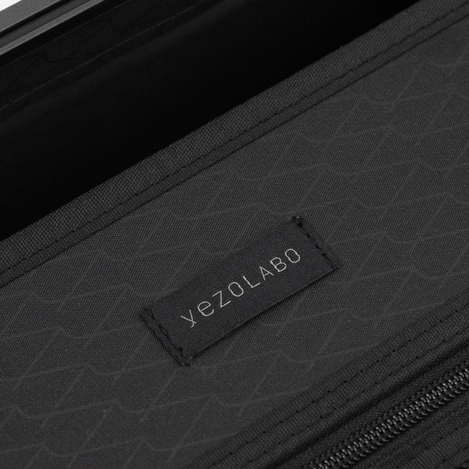 アイシクル フレームスーツケース（キャリーケース）のインナーネームはyezoLABO（エゾラボ）のブランドロゴがあしわられた織ネームを配置。